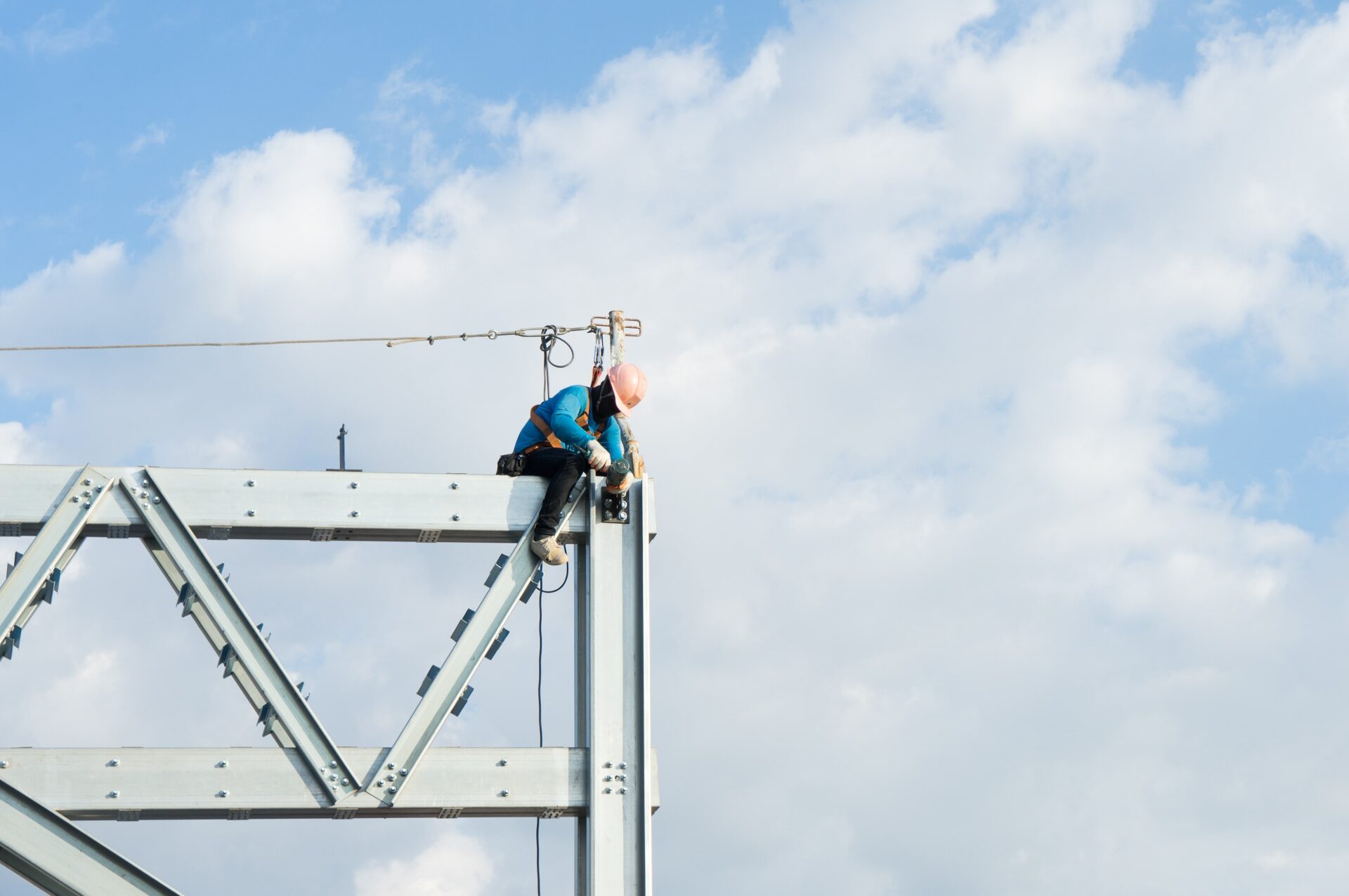 A construction worker in high-visibility gear navigating a timber roof frame, highlighting safety compliance and working at heights certification for residential building sites.
