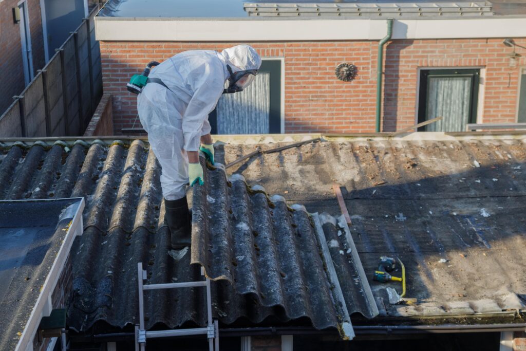Link Resources supervise asbestos removal course worker removing asbestos roofing with protective equipment