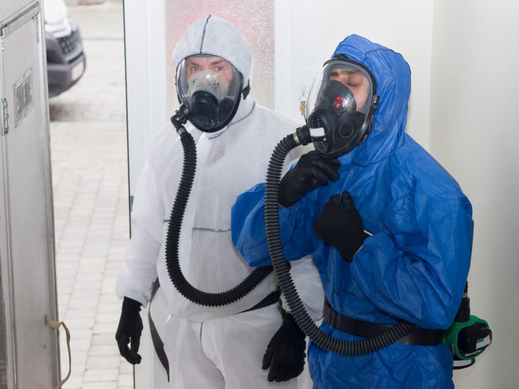 Link Resources supervise asbestos removal course workers wearing respirators and protective suits